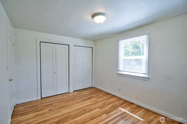 819 Decatur St SW, Olympia, WA 98502 - unfurnished bedroom with light wood finished floors, baseboards, and multiple closets