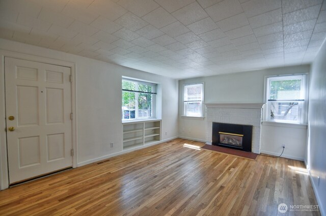 819 Decatur St SW, Olympia, WA 98502 - unfurnished living room with baseboards, wood finished floors, a fireplace, and visible vents