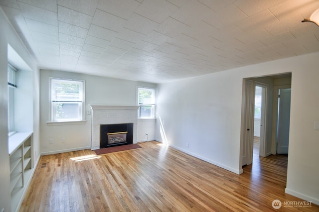 819 Decatur St SW, Olympia, WA 98502 - unfurnished living room featuring a fireplace, baseboards, visible vents, and light wood-style floors