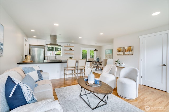 living area featuring light wood-type flooring and recessed lighting