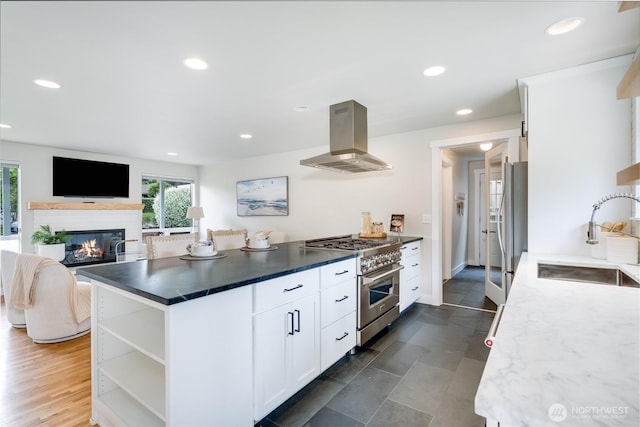 kitchen with island exhaust hood, stainless steel appliances, a sink, open shelves, and white cabinetry