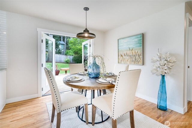 dining area with light wood-style flooring and baseboards