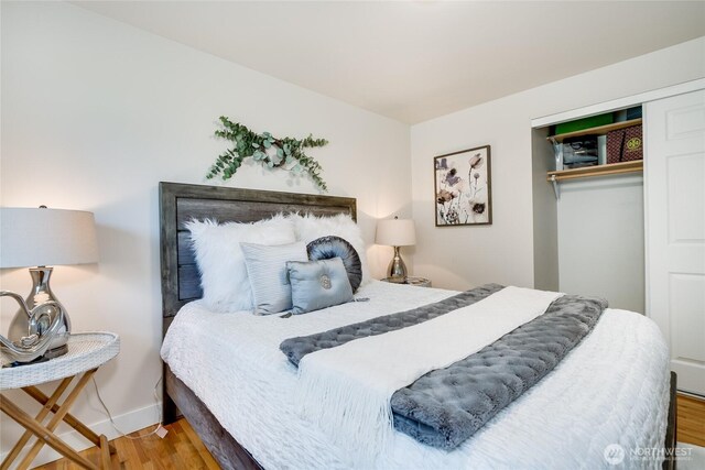 bedroom featuring wood finished floors, a closet, and baseboards
