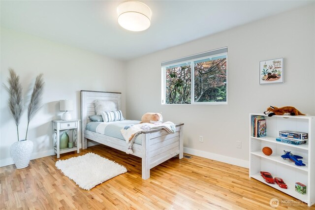 bedroom with wood finished floors and baseboards