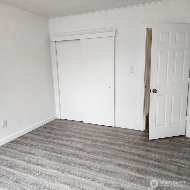 705 E 54th St, Tacoma, WA 98404 - unfurnished bedroom featuring a closet, wood finished floors, and baseboards