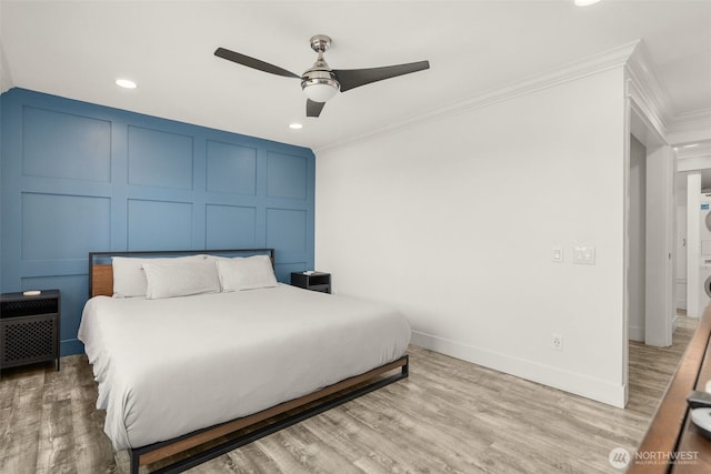 716 W Argand St Unit C, Seattle, WA 98119 - bedroom with stacked washing machine and dryer, a decorative wall, crown molding, recessed lighting, and light wood-type flooring