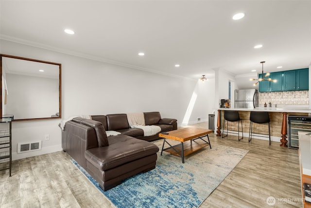 716 W Argand St Unit C, Seattle, WA 98119 - living area featuring ornamental molding, light wood-type flooring, wine cooler, a chandelier, and baseboards