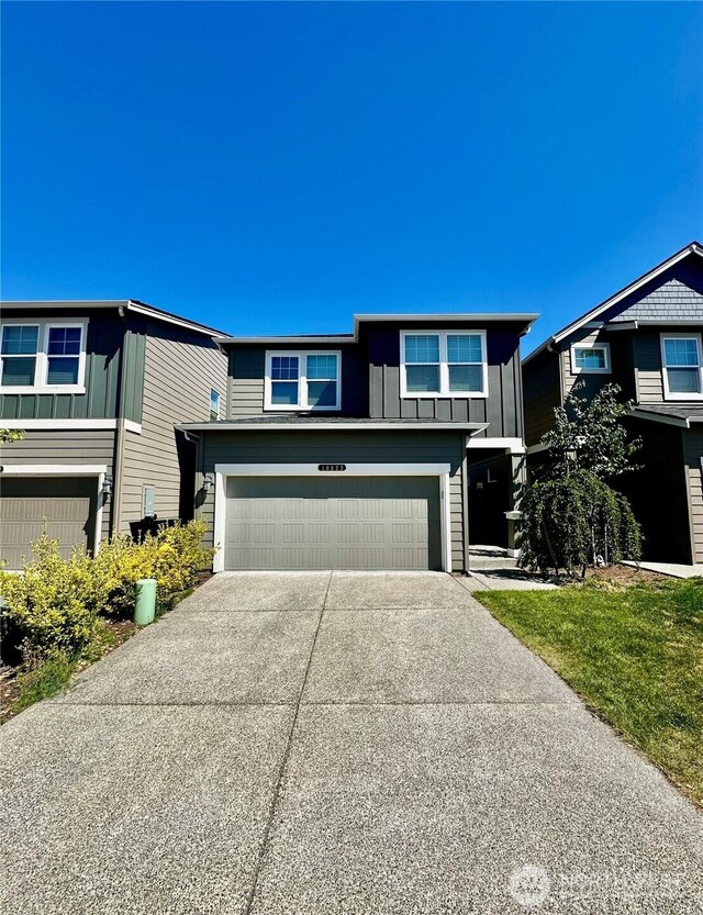 10823 187th Street Ct E, Puyallup, WA 98374 - view of front of home with an attached garage, concrete driveway, and board and batten siding
