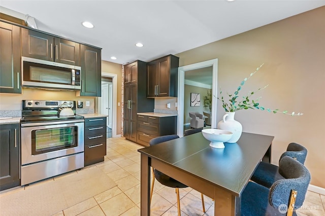 kitchen featuring stainless steel appliances, light countertops, light tile patterned flooring, recessed lighting, and dark brown cabinets