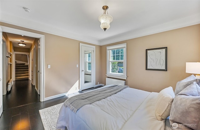 bedroom with radiator, baseboards, and dark wood finished floors
