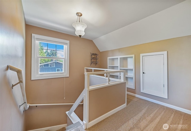 additional living space featuring built in features, baseboards, lofted ceiling, and carpet flooring