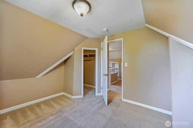 additional living space with carpet floors, vaulted ceiling, and baseboards