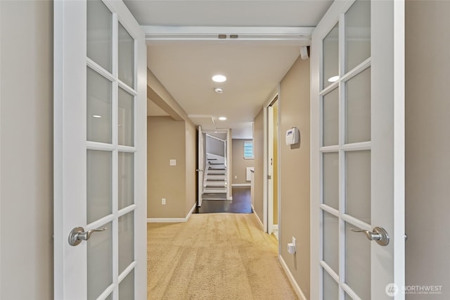 hallway featuring carpet flooring, baseboards, recessed lighting, french doors, and stairway