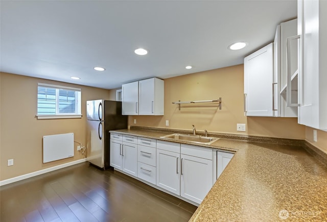 kitchen with freestanding refrigerator, a sink, white cabinetry, radiator, and recessed lighting