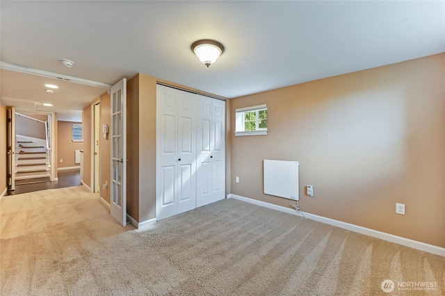 unfurnished bedroom featuring baseboards, carpet, and a closet