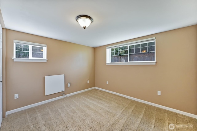 spare room featuring baseboards and carpet