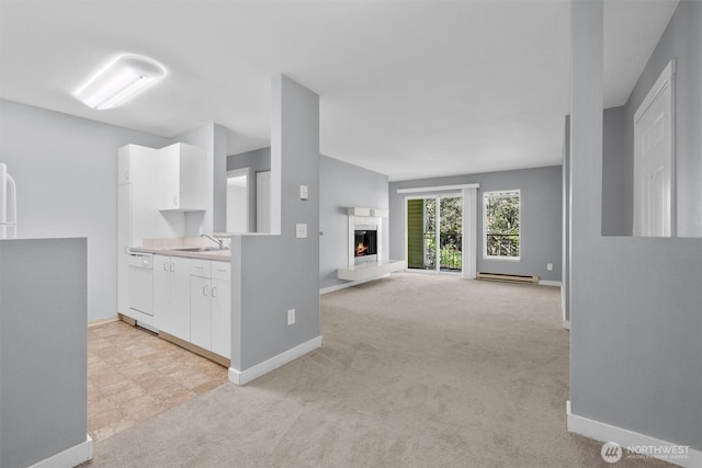 12303 Harbour Pointe Blvd Unit U202, Mukilteo, WA 98275 - kitchen featuring white dishwasher, white cabinetry, a sink, baseboard heating, and baseboards