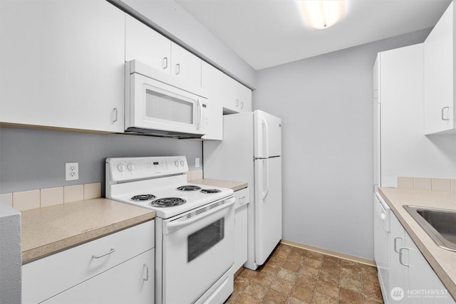12303 Harbour Pointe Blvd Unit U202, Mukilteo, WA 98275 - kitchen featuring white appliances, stone finish flooring, light countertops, white cabinets, and baseboards