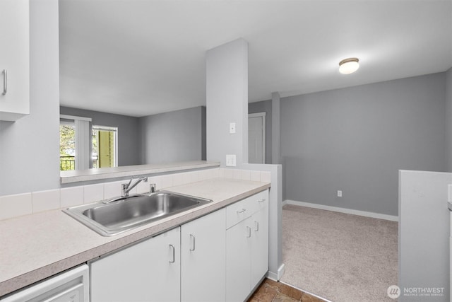12303 Harbour Pointe Blvd Unit U202, Mukilteo, WA 98275 - kitchen featuring a sink, light countertops, white cabinets, baseboards, and carpet flooring