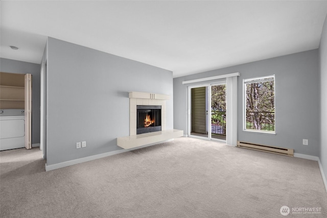 12303 Harbour Pointe Blvd Unit U202, Mukilteo, WA 98275 - unfurnished living room featuring washer / clothes dryer, baseboard heating, carpet, and a tiled fireplace