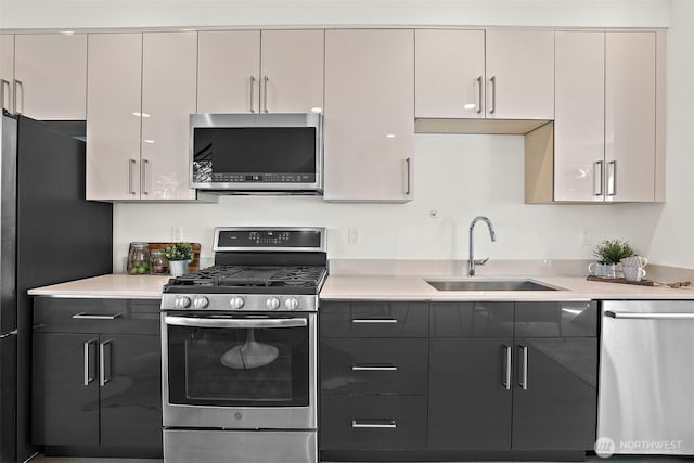 kitchen with stainless steel appliances, a sink, and light countertops