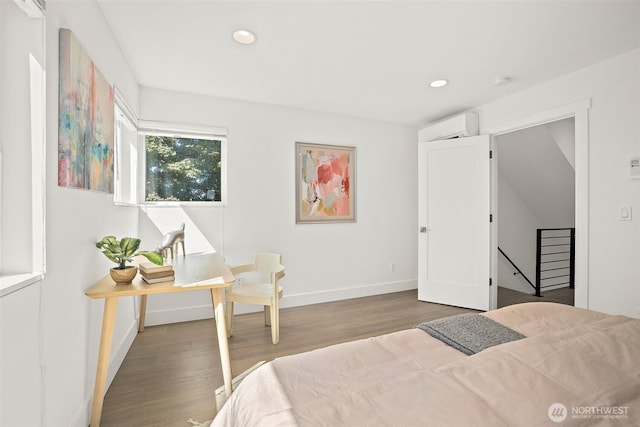 bedroom with a wall mounted air conditioner, wood finished floors, recessed lighting, and baseboards