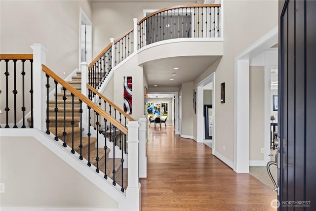 entrance foyer with stairs, recessed lighting, a high ceiling, and wood finished floors