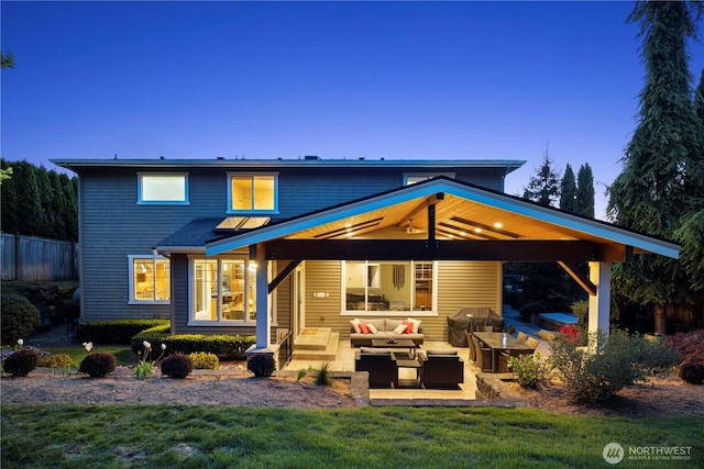 rear view of property featuring a gazebo, fence, a yard, a patio, and an outdoor living space