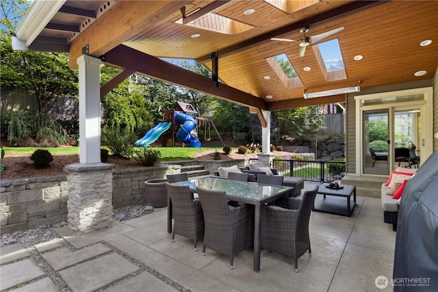 view of patio / terrace with ceiling fan, a playground, and outdoor dining space