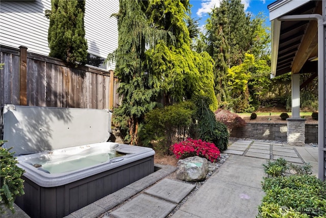 view of yard with hot tub deck surround and fence