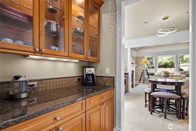 bar with backsplash, light carpet, a fireplace, and crown molding