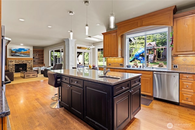 kitchen featuring light wood finished floors, a sink, and stainless steel dishwasher