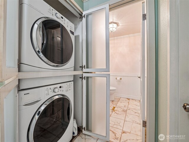 washroom with light marble finish flooring and stacked washer / dryer