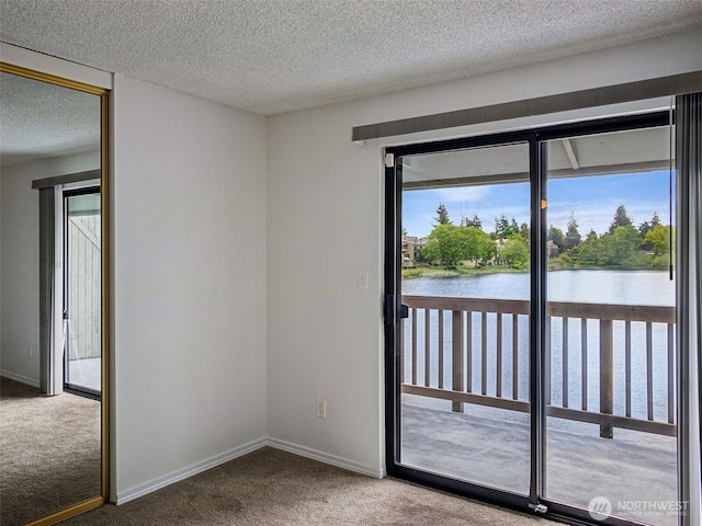 doorway featuring carpet floors, a water view, a textured ceiling, and baseboards