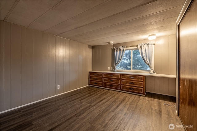 211 Pace Dr Unit 16, East Wenatchee, WA 98802 - unfurnished room with wood finished floors, baseboards, wooden walls, and a desk