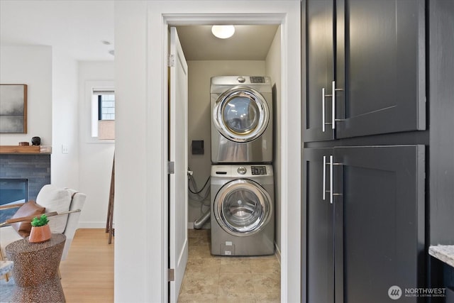 washroom featuring estacked washer and dryer and baseboards