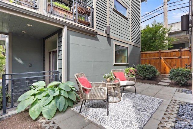 view of patio / terrace with a balcony and fence