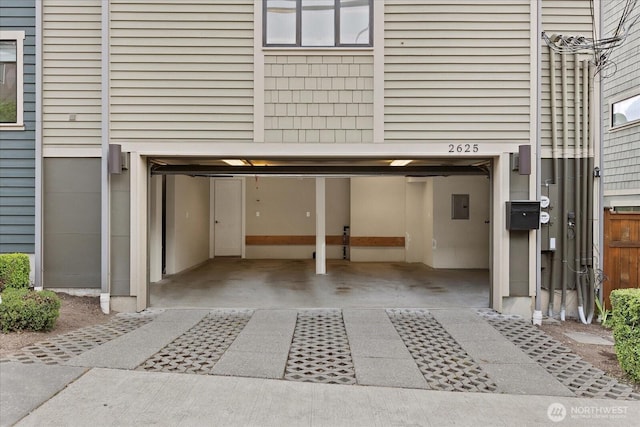 garage with electric panel and driveway