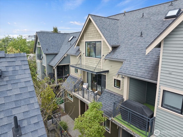 back of property featuring roof with shingles