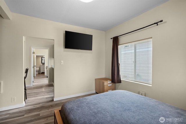 bedroom with wood finished floors and baseboards