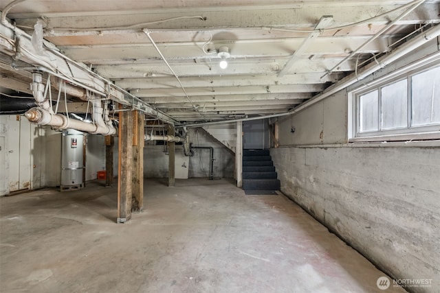 basement featuring water heater and stairs