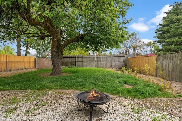 fenced backyard with a fire pit