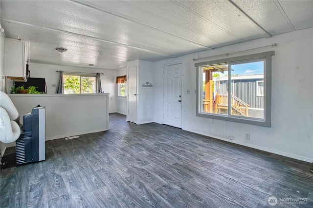 entrance foyer with wood finished floors, a textured ceiling, and baseboards