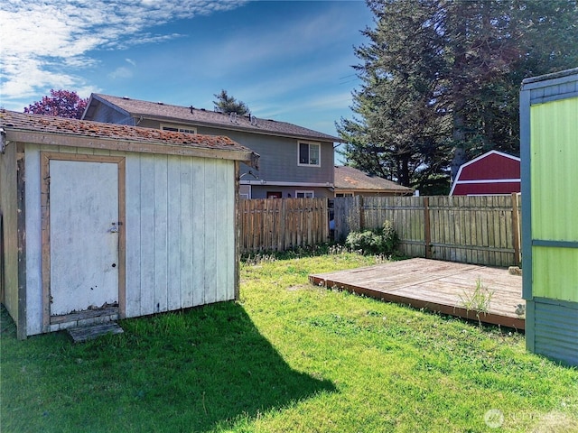 view of yard featuring a shed, an outbuilding, and a wooden deck