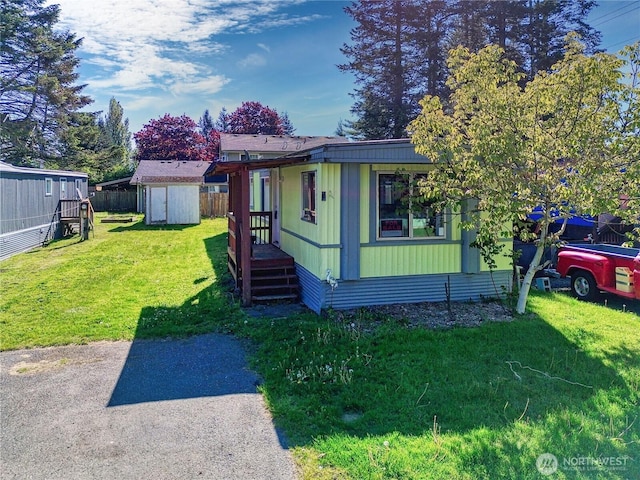 view of front of home with a storage shed and an outbuilding