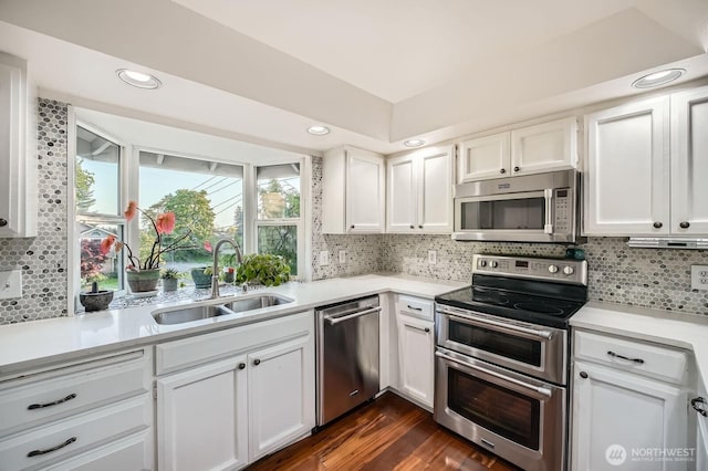1851 58th St NE, Tacoma, WA 98422 - kitchen featuring appliances with stainless steel finishes, a sink, white cabinetry, light countertops, and backsplash
