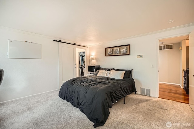 1851 58th St NE, Tacoma, WA 98422 - carpeted bedroom with a barn door, crown molding, baseboards, a walk in closet, and a closet