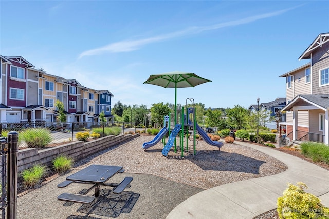 community play area featuring fence and a residential view