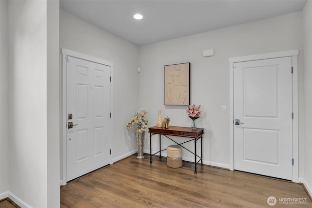 foyer entrance with wood finished floors, baseboards, and recessed lighting