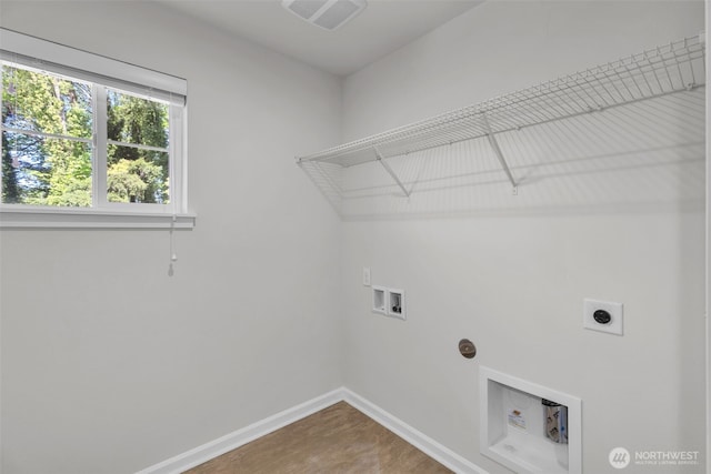 washroom featuring hookup for an electric dryer, hookup for a washing machine, baseboards, and wood finished floors